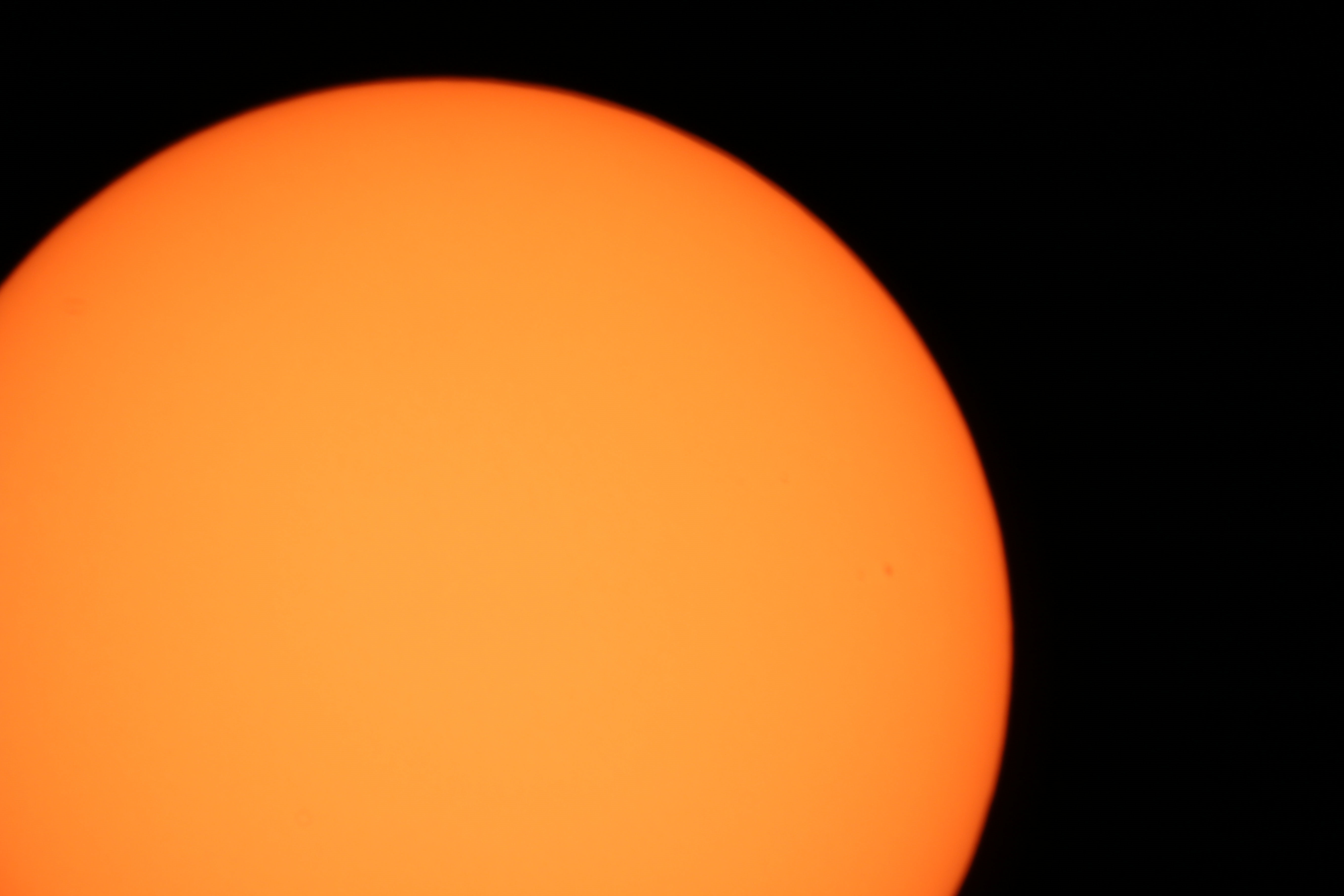 Sol by Jim Barber undated. Canon 70d 1/60 the on the 8" sct.  "This photo is through a solar filter, I took this image and selected the complimentary colour to enhance the sunspot to make it clearer."
